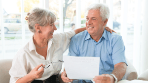 Un couple senior souriant discutant d'un document d'assurance dans un cadre lumineux